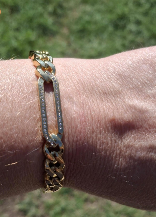 Rigid bracelet with zirconium-set charm, made of stainless steel 316.