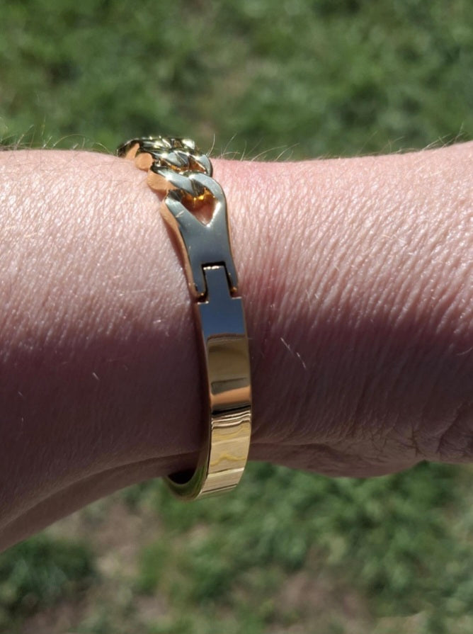 Rigid bracelet with zirconium-set charm, made of stainless steel 316.