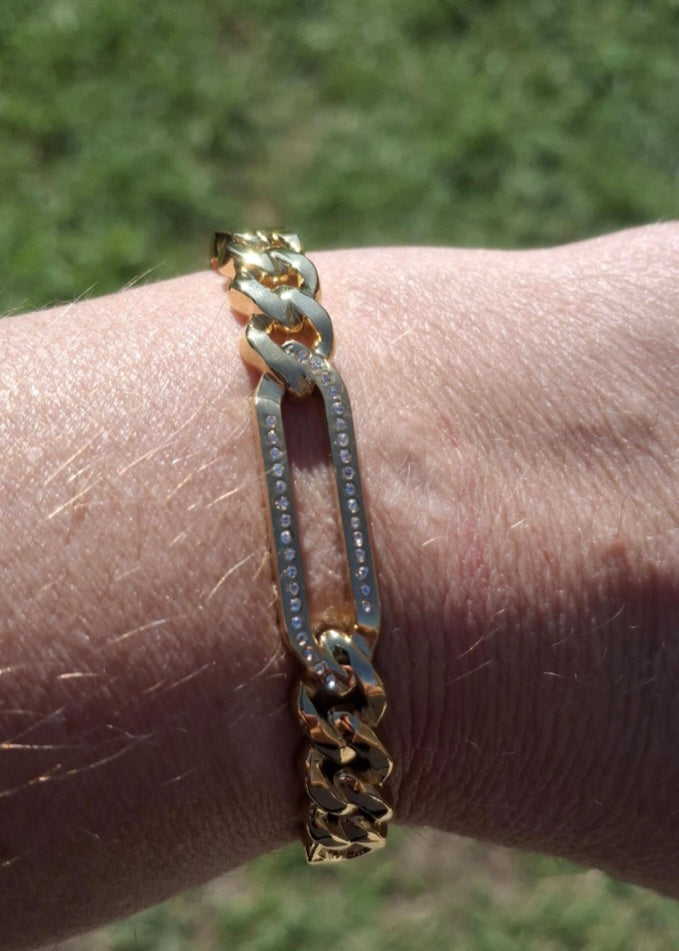 Rigid bracelet with zirconium-set charm, made of stainless steel 316.