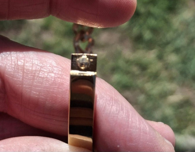 Rigid bracelet with zirconium-set charm, made of stainless steel 316.